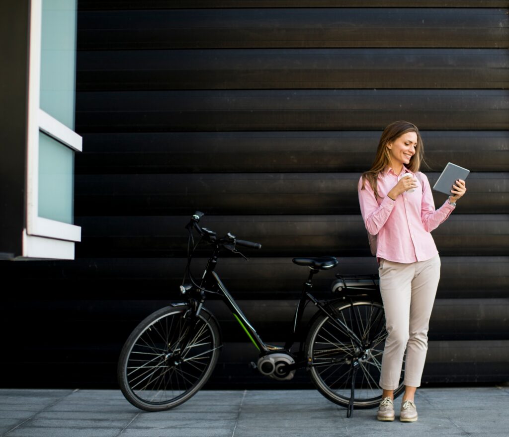 Young woman with tablet and e-bike outdoor