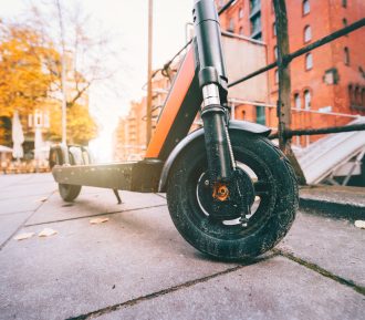 Close up of Electric kick scooter or e-scooter parked on pavement - e-mobility or micro-mobility